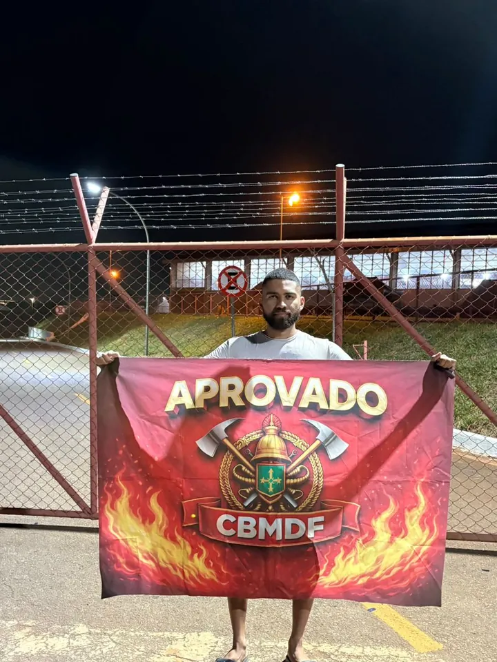 Aluno aprovado segurando bandeira de aprovação no TAF
